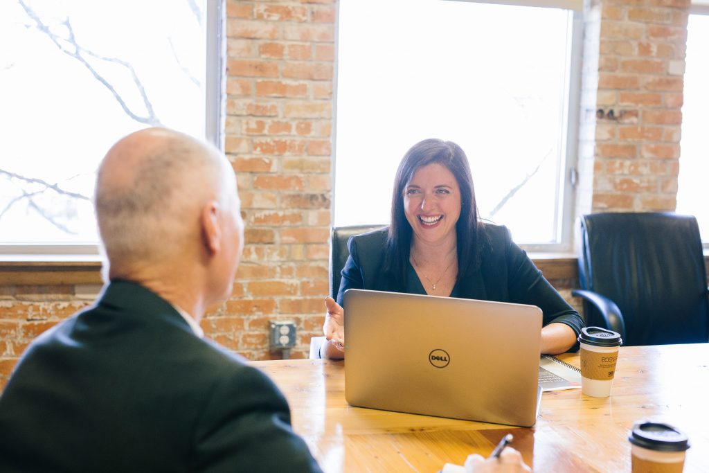 Man woman business laughing talking advice computer table smile